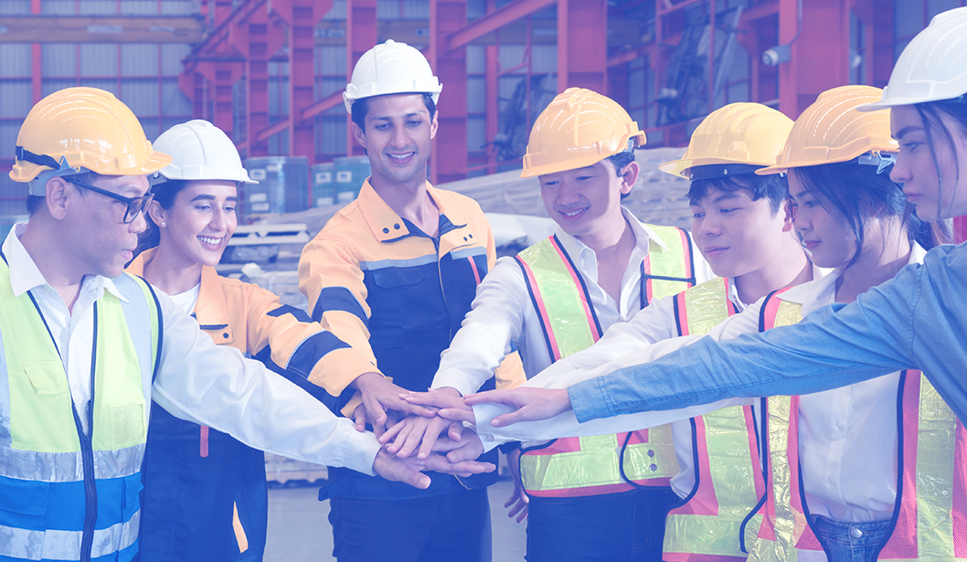 Trabajadores industriales uniendo sus manos en símbolo de trabajo en equipo